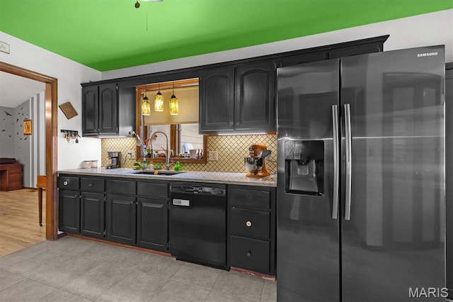 kitchen featuring stainless steel refrigerator with ice dispenser, black dishwasher, a sink, backsplash, and light countertops