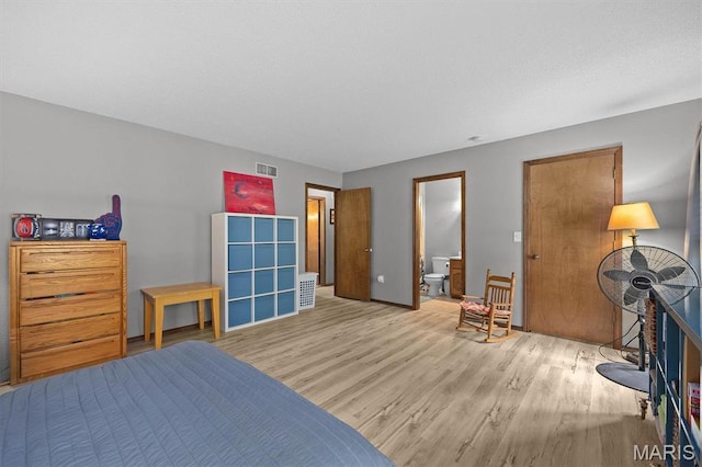 bedroom with light wood finished floors, ensuite bathroom, and baseboards