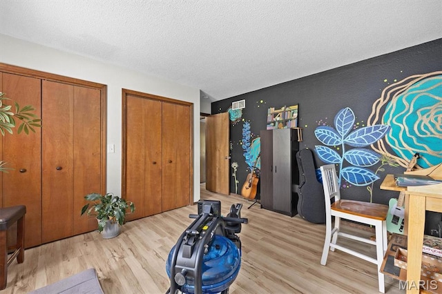 workout area featuring wood finished floors and a textured ceiling