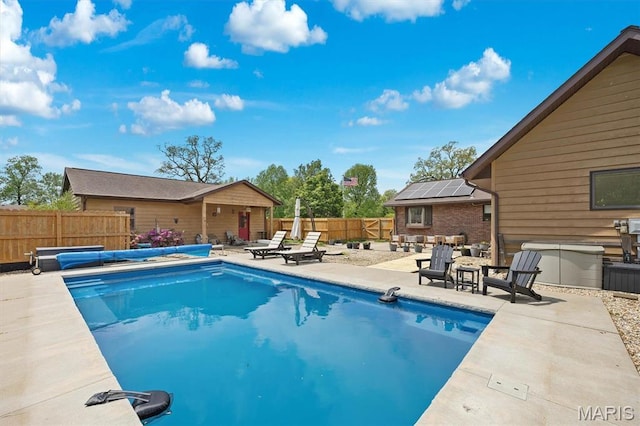 view of swimming pool with a patio area, a fenced backyard, and an outbuilding