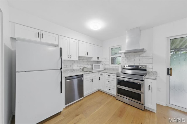 3214 Roger Williams Dr Unit D, Bridgeton, MO 63044 - kitchen with appliances with stainless steel finishes, range hood, a sink, decorative backsplash, and white cabinets