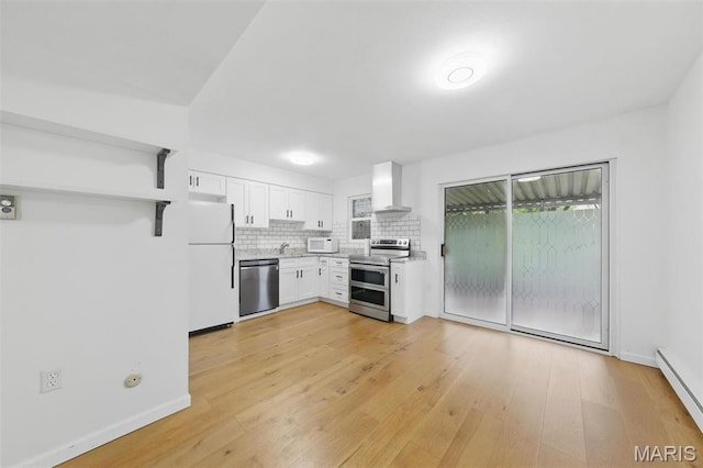 3214 Roger Williams Dr Unit D, Bridgeton, MO 63044 - kitchen featuring appliances with stainless steel finishes, wall chimney exhaust hood, baseboard heating, white cabinets, and tasteful backsplash
