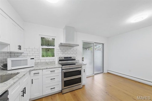 3214 Roger Williams Dr Unit D, Bridgeton, MO 63044 - kitchen with wall chimney exhaust hood, double oven range, white microwave, white cabinetry, and a baseboard radiator