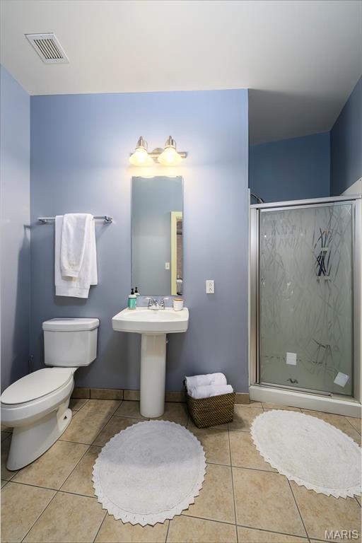 901 Washington Ave Unit 411, Saint Louis, MO 63101 - bathroom featuring toilet, tile patterned flooring, and a shower stall