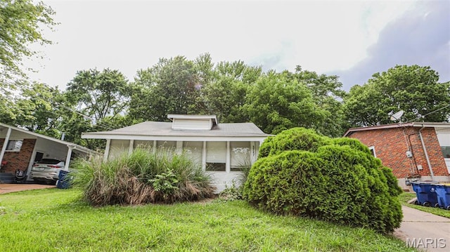 bungalow-style house featuring a front yard and a carport