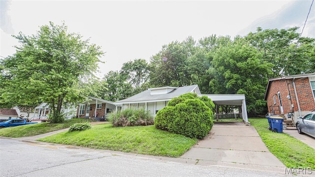 view of front of property featuring a front lawn, driveway, and a detached carport