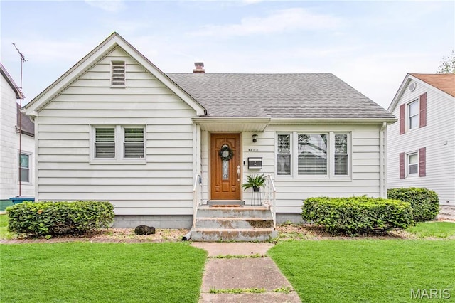 1404 Lemon St, Highland, IL 62249 - bungalow with a front lawn, roof with shingles, and a chimney