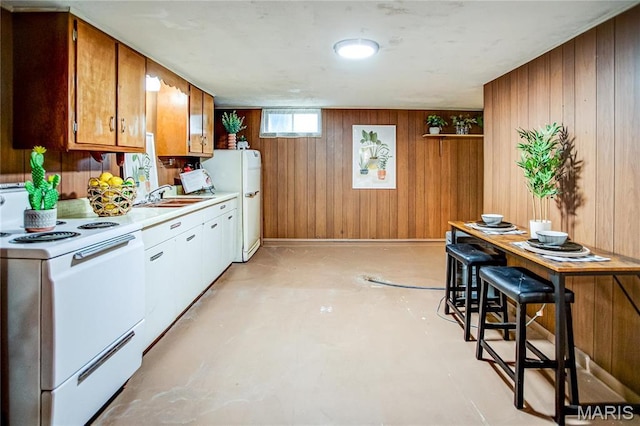 1404 Lemon St, Highland, IL 62249 - kitchen with white appliances, wood walls, light countertops, brown cabinets, and finished concrete flooring