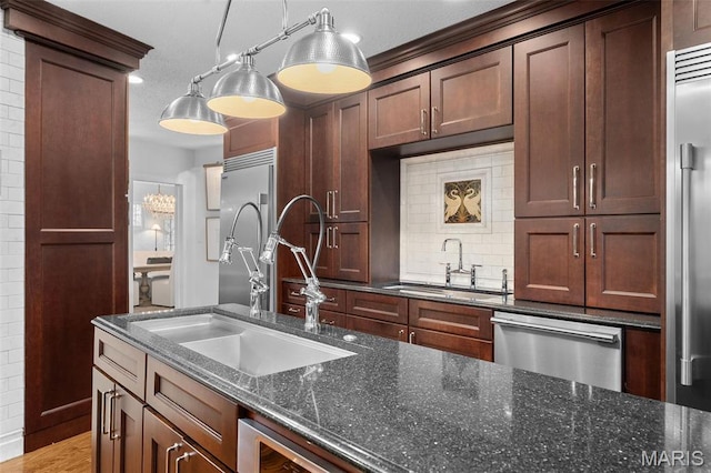 2 Northcote Rd, Saint Louis, MO 63144 - kitchen featuring a sink, appliances with stainless steel finishes, backsplash, and hanging light fixtures