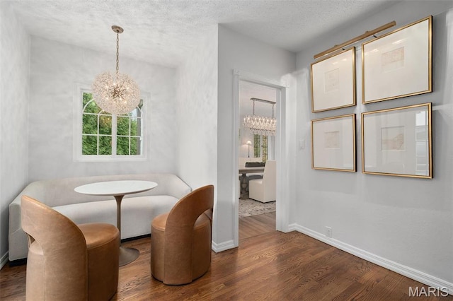 2 Northcote Rd, Saint Louis, MO 63144 - dining room with a chandelier, wood finished floors, baseboards, and a textured ceiling