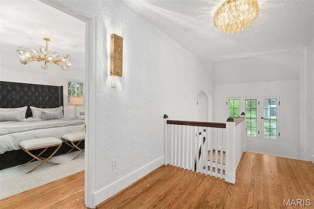 2 Northcote Rd, Saint Louis, MO 63144 - corridor featuring a chandelier, an upstairs landing, wood finished floors, vaulted ceiling, and baseboards