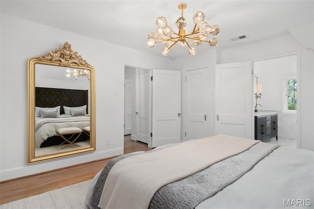 2 Northcote Rd, Saint Louis, MO 63144 - bedroom featuring a chandelier, wood finished floors, and ensuite bathroom