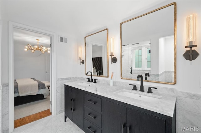 2 Northcote Rd, Saint Louis, MO 63144 - full bathroom featuring ensuite bathroom, double vanity, a wainscoted wall, tile walls, and a chandelier