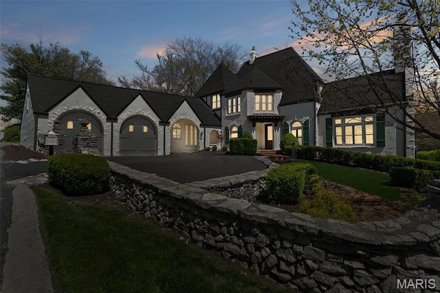 2 Northcote Rd, Saint Louis, MO 63144 - french country style house with asphalt driveway, a chimney, and an attached garage