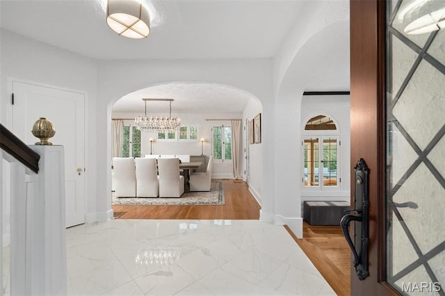 2 Northcote Rd, Saint Louis, MO 63144 - foyer with arched walkways, a chandelier, marble finish floors, and baseboards