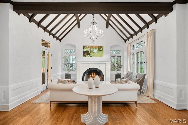2 Northcote Rd, Saint Louis, MO 63144 - living room with arched walkways, a lit fireplace, french doors, beamed ceiling, and wood finished floors
