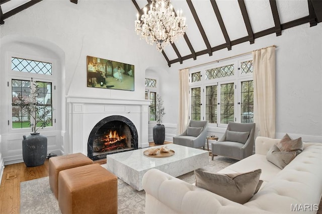 2 Northcote Rd, Saint Louis, MO 63144 - living room featuring high vaulted ceiling, wood finished floors, a lit fireplace, beamed ceiling, and a chandelier