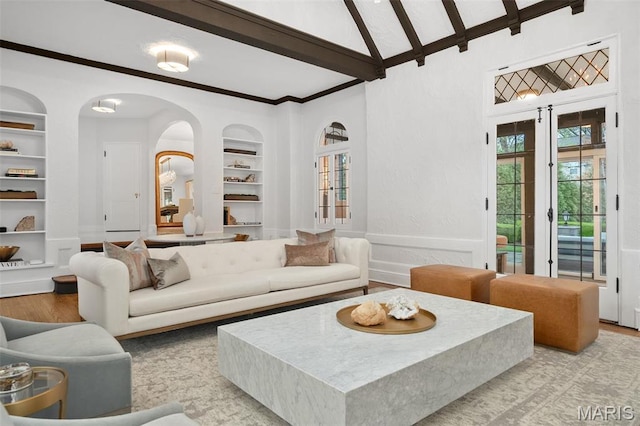 2 Northcote Rd, Saint Louis, MO 63144 - living room featuring built in shelves, beam ceiling, light wood-style floors, high vaulted ceiling, and arched walkways