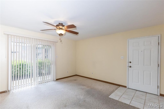 spare room with ceiling fan, light carpet, and baseboards