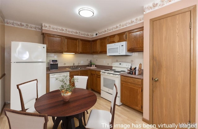 7416 Triwoods Dr Unit A, Saint Louis, MO 63119 - kitchen with white appliances, light wood-type flooring, brown cabinetry, and tasteful backsplash