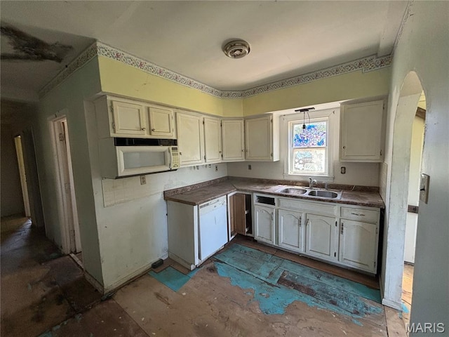 6966 Front St, Barnhart, MO 63012 - kitchen with a sink, white appliances, arched walkways, and dark countertops