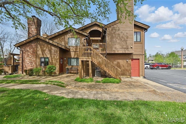 view of front of property featuring a chimney, stairs, and a deck