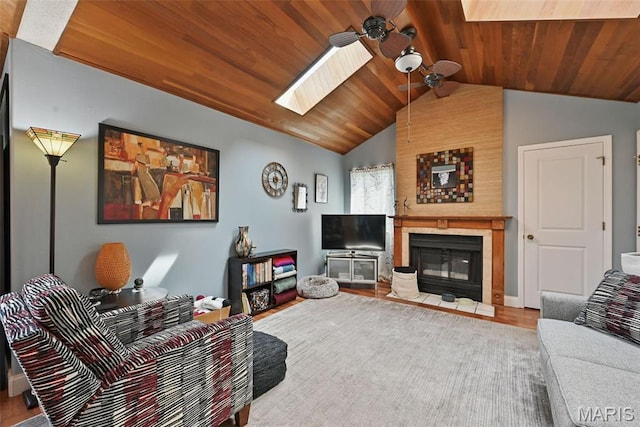 living room featuring a skylight, a ceiling fan, wood ceiling, vaulted ceiling, and wood finished floors