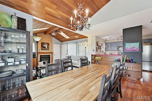 dining room with wood ceiling, a ceiling fan, wood finished floors, and a chandelier