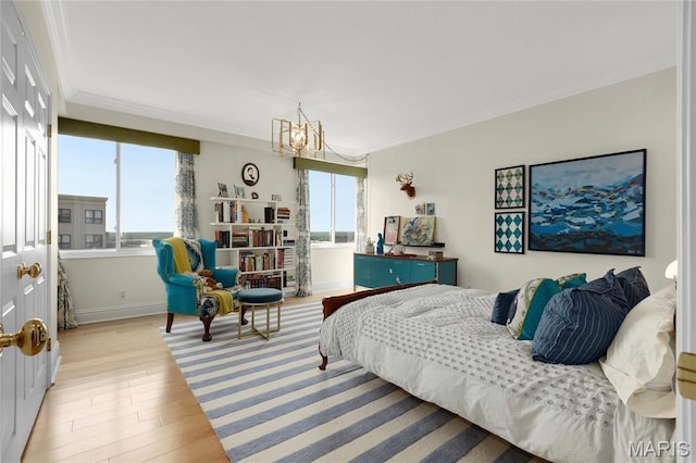 900 S Hanley Rd Unit 15E, Clayton, MO 63105 - bedroom with multiple windows, a chandelier, crown molding, light wood-type flooring, and baseboards