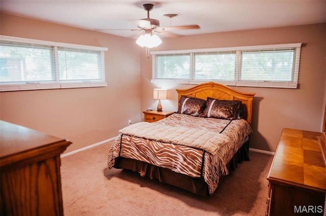 carpeted bedroom with multiple windows, baseboards, and ceiling fan