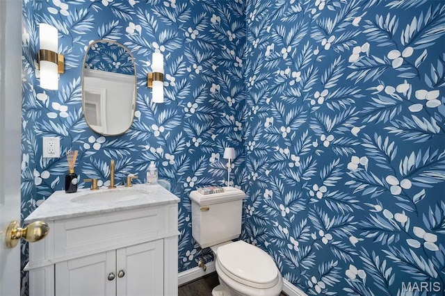 14 Brighton Way, Clayton, MO 63105 - half bathroom featuring wallpapered walls, toilet, vanity, wood finished floors, and baseboards