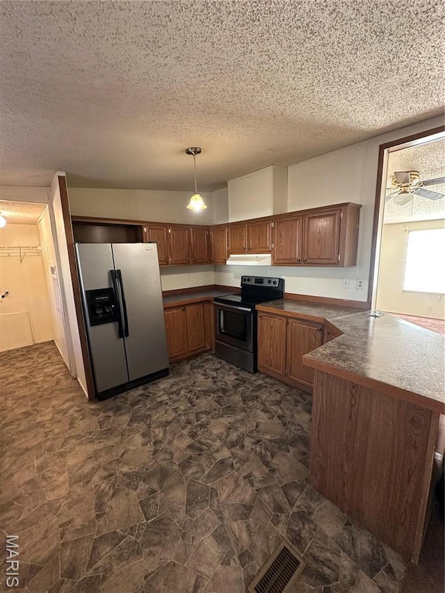549 E Outer Rd, Sikeston, MO 63801 - kitchen featuring appliances with stainless steel finishes, under cabinet range hood, a textured ceiling, a peninsula, and brown cabinets