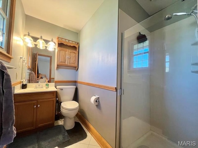 bathroom with a shower stall, toilet, tile patterned floors, vanity, and baseboards
