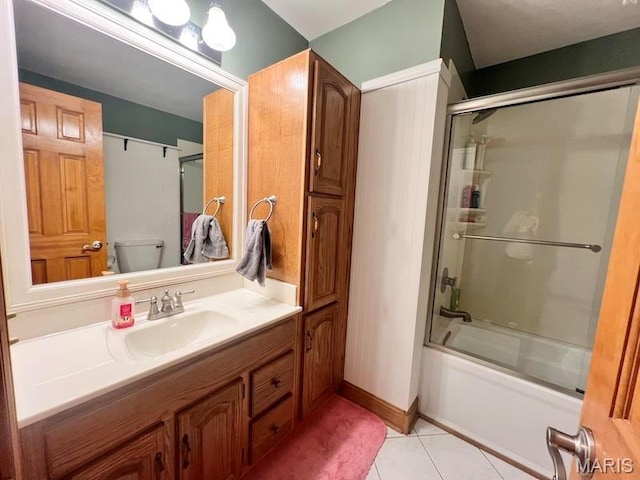 full bathroom featuring shower / bath combination with glass door, tile patterned floors, vanity, and toilet