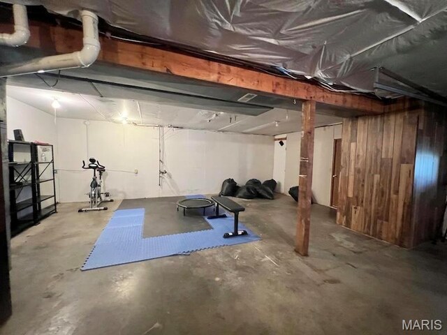 unfinished below grade area featuring wooden walls