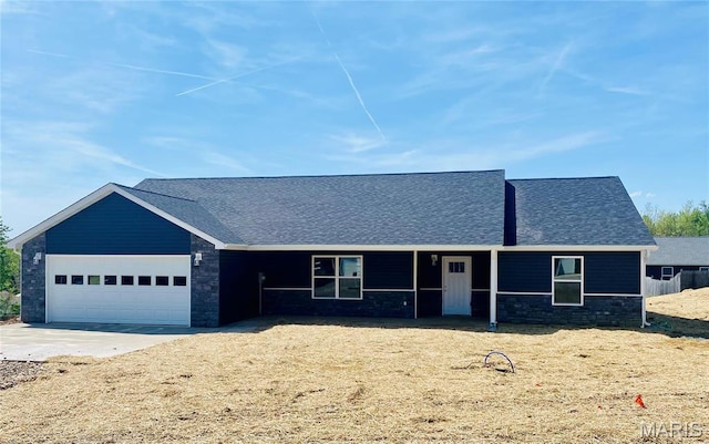 ranch-style house featuring an attached garage, roof with shingles, driveway, and stone siding