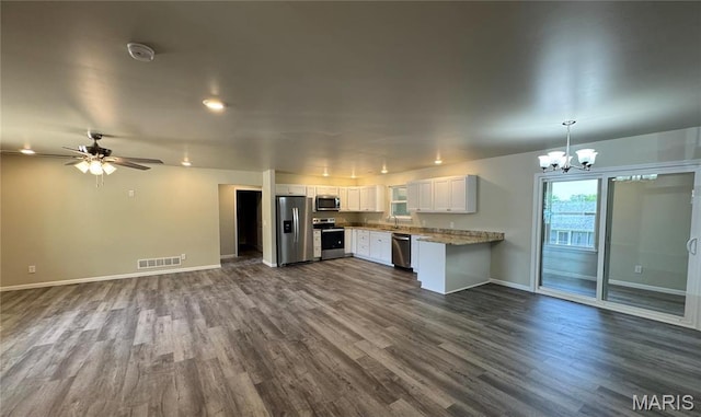 kitchen featuring appliances with stainless steel finishes, open floor plan, baseboards, a chandelier, and dark wood-style flooring