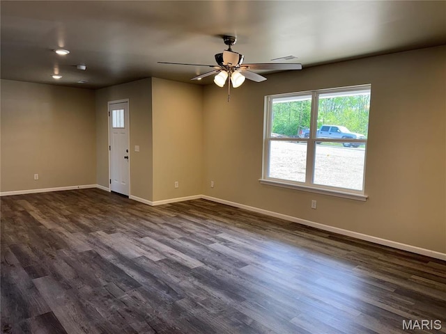 unfurnished room featuring a ceiling fan, dark wood finished floors, and baseboards