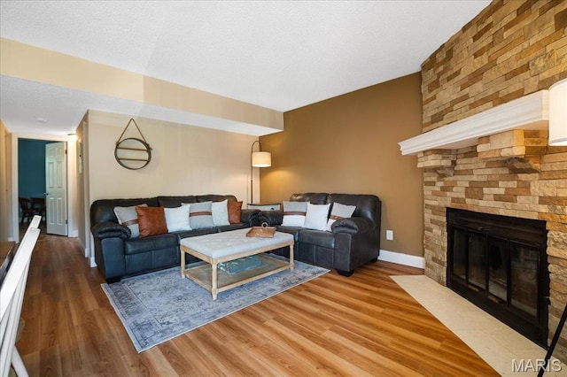 9005 Cardinal Ter, Saint Louis, MO 63144 - living area featuring wood finished floors, a fireplace, baseboards, and a textured ceiling
