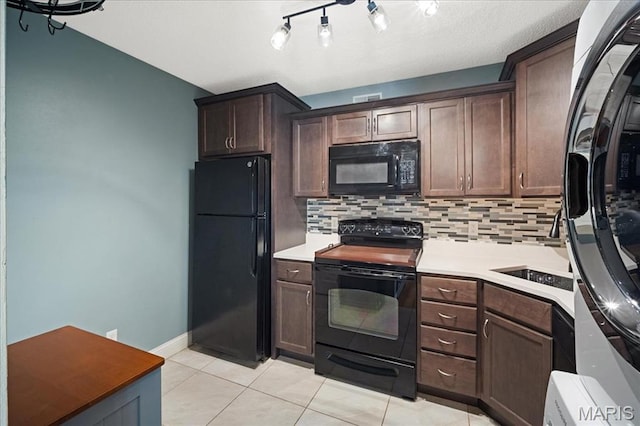 9005 Cardinal Ter, Saint Louis, MO 63144 - kitchen featuring black appliances, tasteful backsplash, light tile patterned flooring, light countertops, and dark brown cabinets