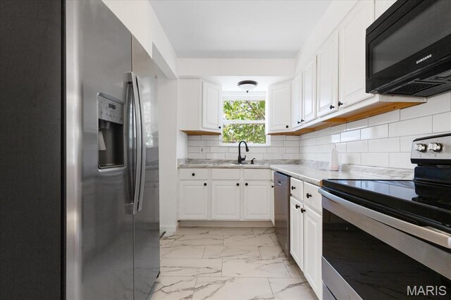 656 Beatrice Ave, Saint Louis, MO 63125 - kitchen with stainless steel appliances, a sink, white cabinets, and light marble finish flooring