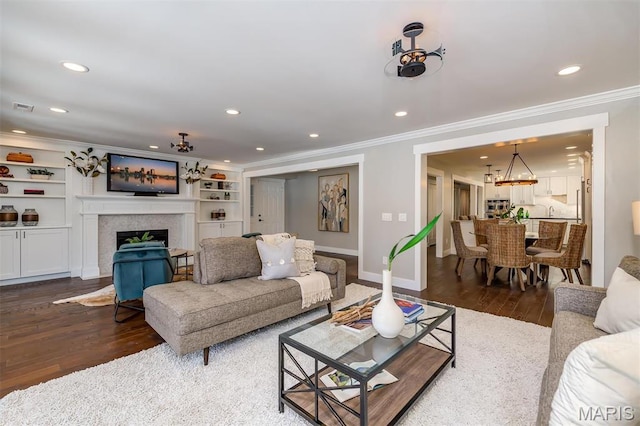 122 N Central Ave Unit A, Saint Louis, MO 63105 - living room featuring crown molding, recessed lighting, dark wood-style floors, a fireplace, and baseboards