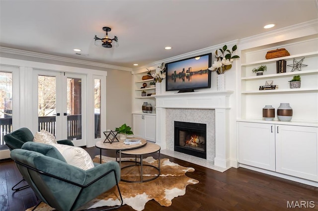 122 N Central Ave Unit A, Saint Louis, MO 63105 - living area featuring dark wood-style flooring, ornamental molding, a fireplace with flush hearth, french doors, and built in features