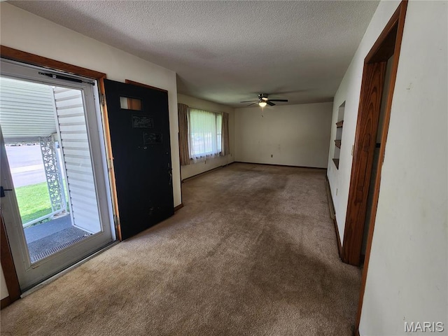 4028 Mcmasters Ave, Hannibal, MO 63401 - unfurnished living room featuring carpet flooring, ceiling fan, a textured ceiling, and baseboards