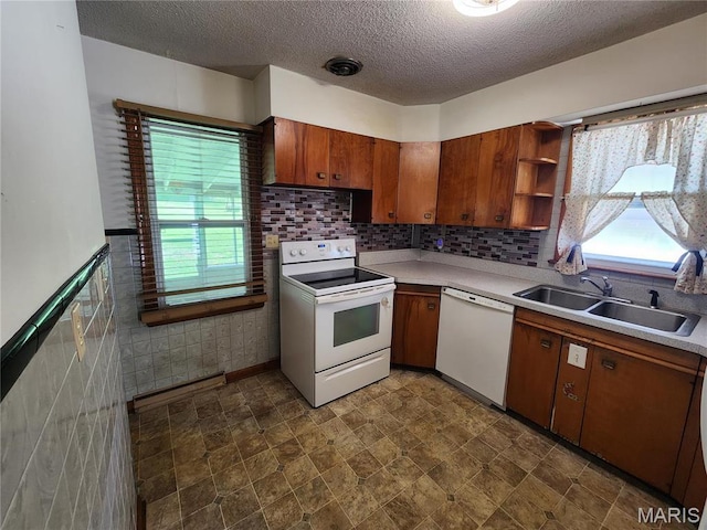 4028 Mcmasters Ave, Hannibal, MO 63401 - kitchen featuring white appliances, a sink, a textured ceiling, brown cabinets, and plenty of natural light