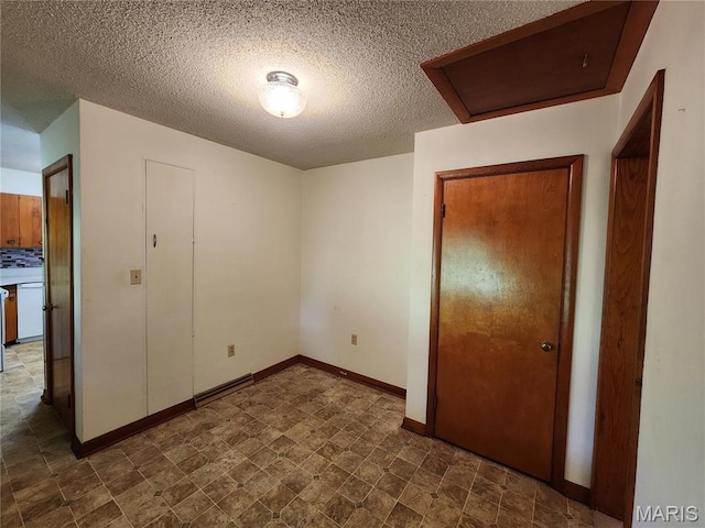 4028 Mcmasters Ave, Hannibal, MO 63401 - unfurnished bedroom featuring attic access, a textured ceiling, and baseboards