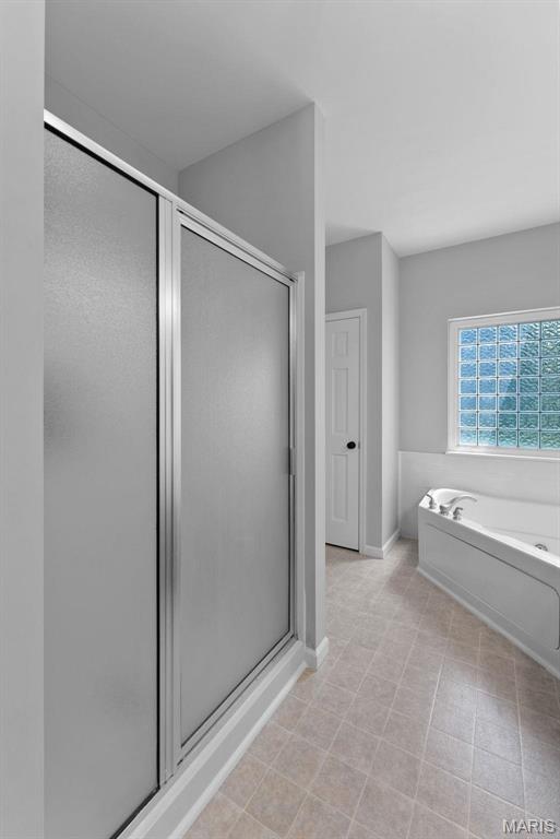220 Cuivre Point Ln, Moscow Mills, MO 63362 - bathroom with a stall shower, a bath, and baseboards
