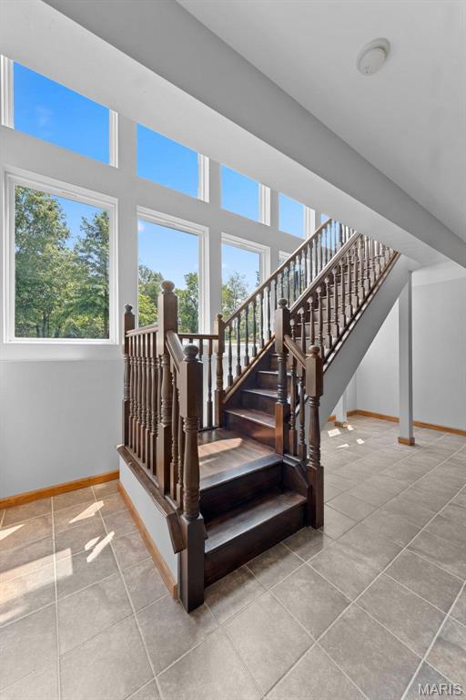 220 Cuivre Point Ln, Moscow Mills, MO 63362 - staircase with plenty of natural light, tile patterned floors, and baseboards