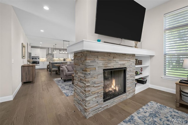207 Castle Stuart Ct, Dardenne Prairie, MO 63368 - living area with dark wood finished floors, a stone fireplace, baseboards, and recessed lighting