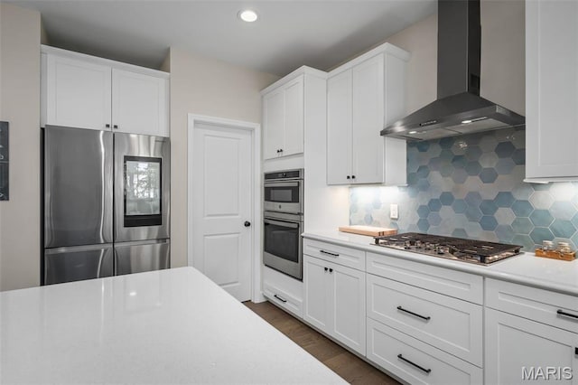 207 Castle Stuart Ct, Dardenne Prairie, MO 63368 - kitchen with stainless steel appliances, wall chimney range hood, backsplash, light countertops, and white cabinets